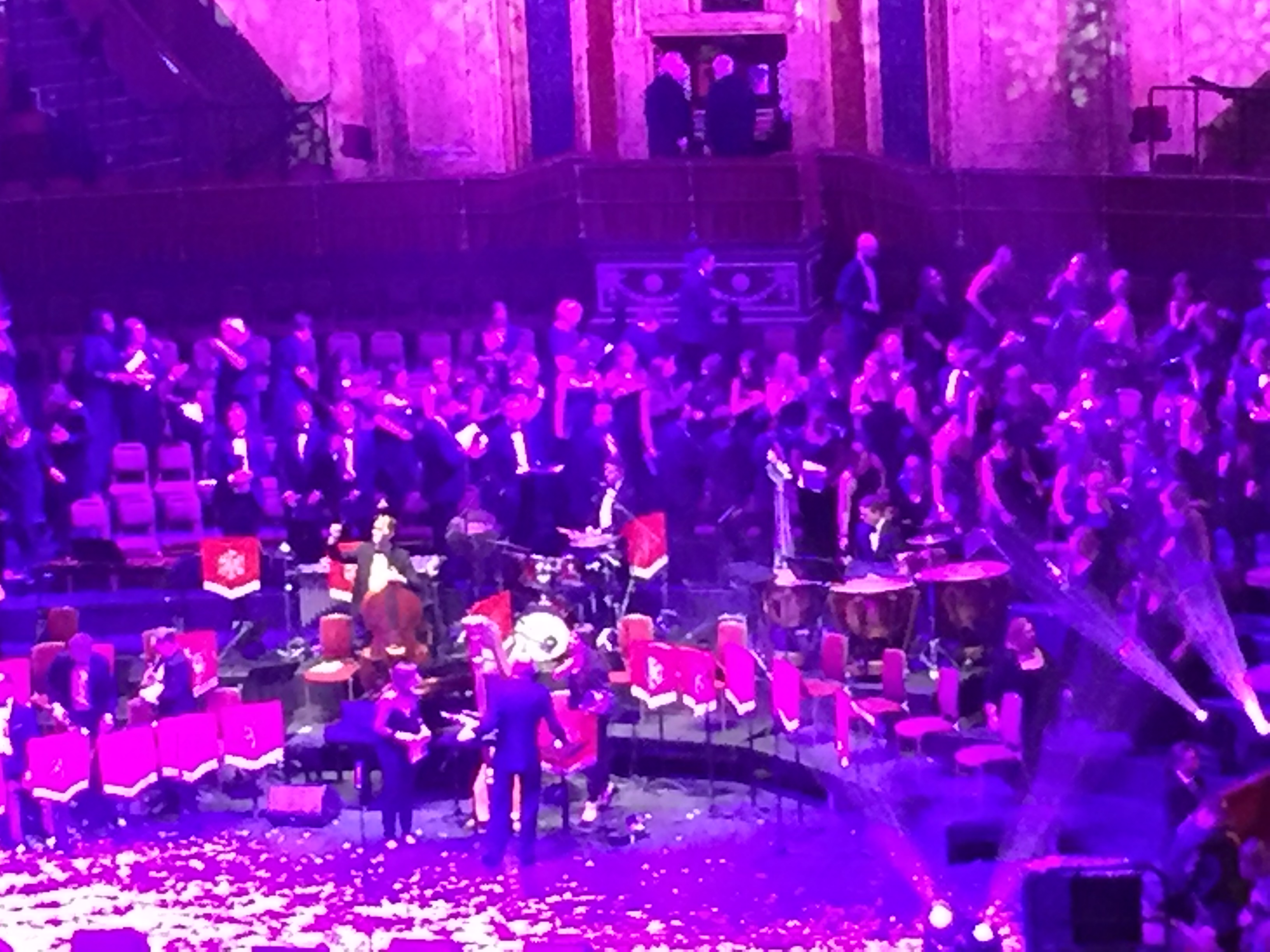 The band and choir leaving the stage, under pink and purple lighting.