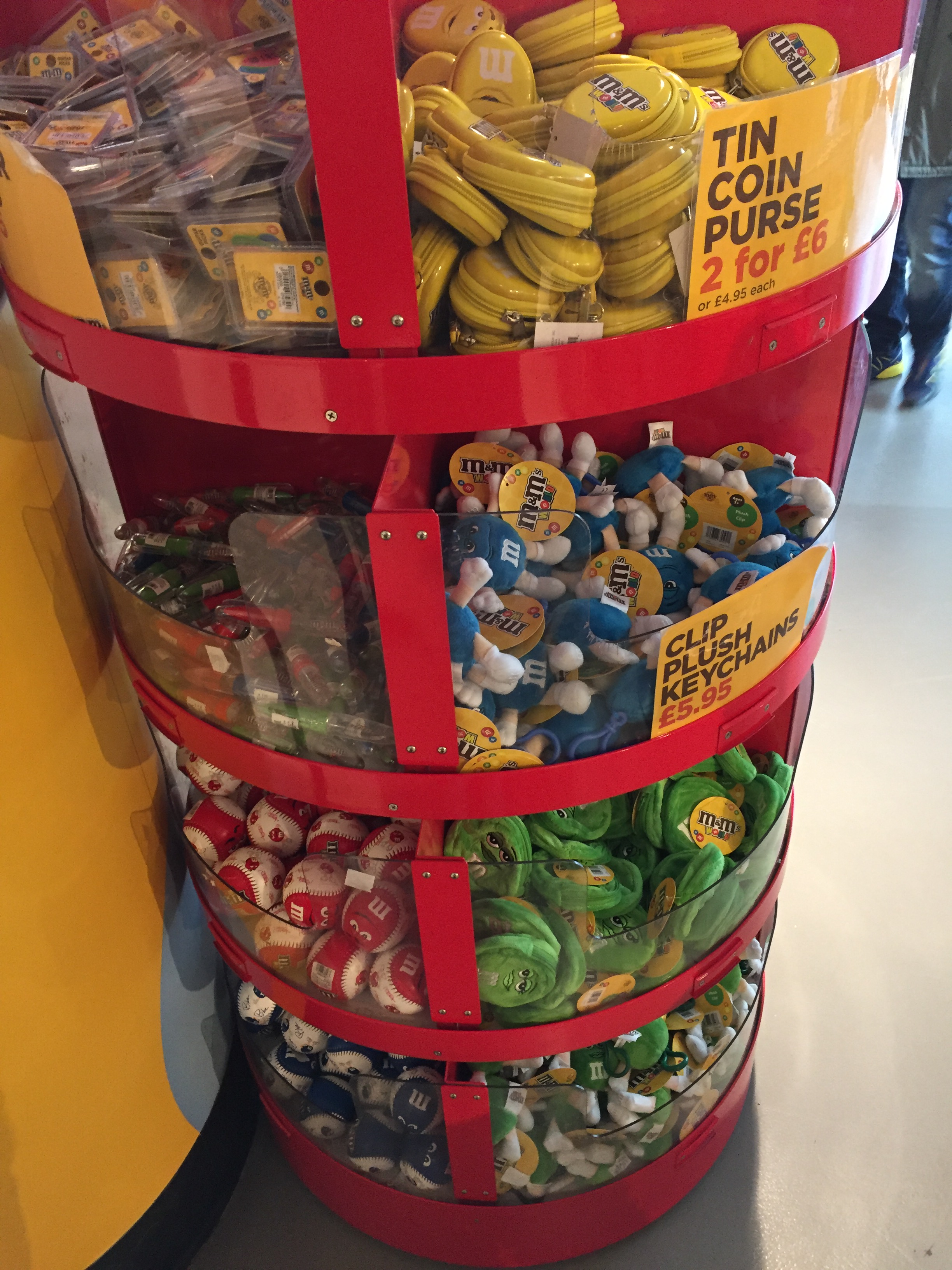 Various items of M&M's branded merchandise, including guitar picks, tin coin purses and plush keychains