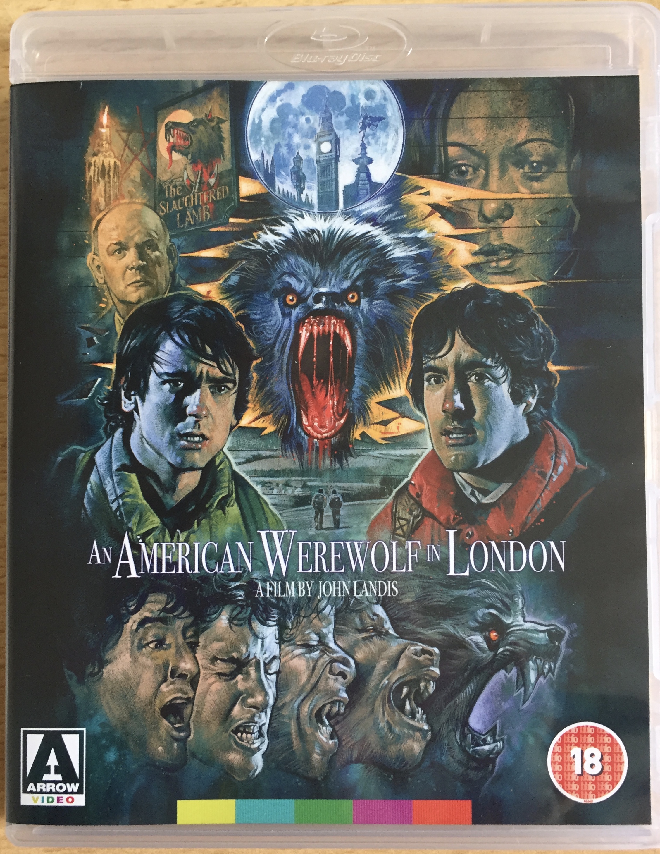 Blu-ray cover for An American Werewolf In London, featuring a colourful painting showing the head of a roaring werewolf surrounded by headshots of the film's main characters. At the bottom, a sequence of 5 headshots illustrates the transformation from human to werewolf.
