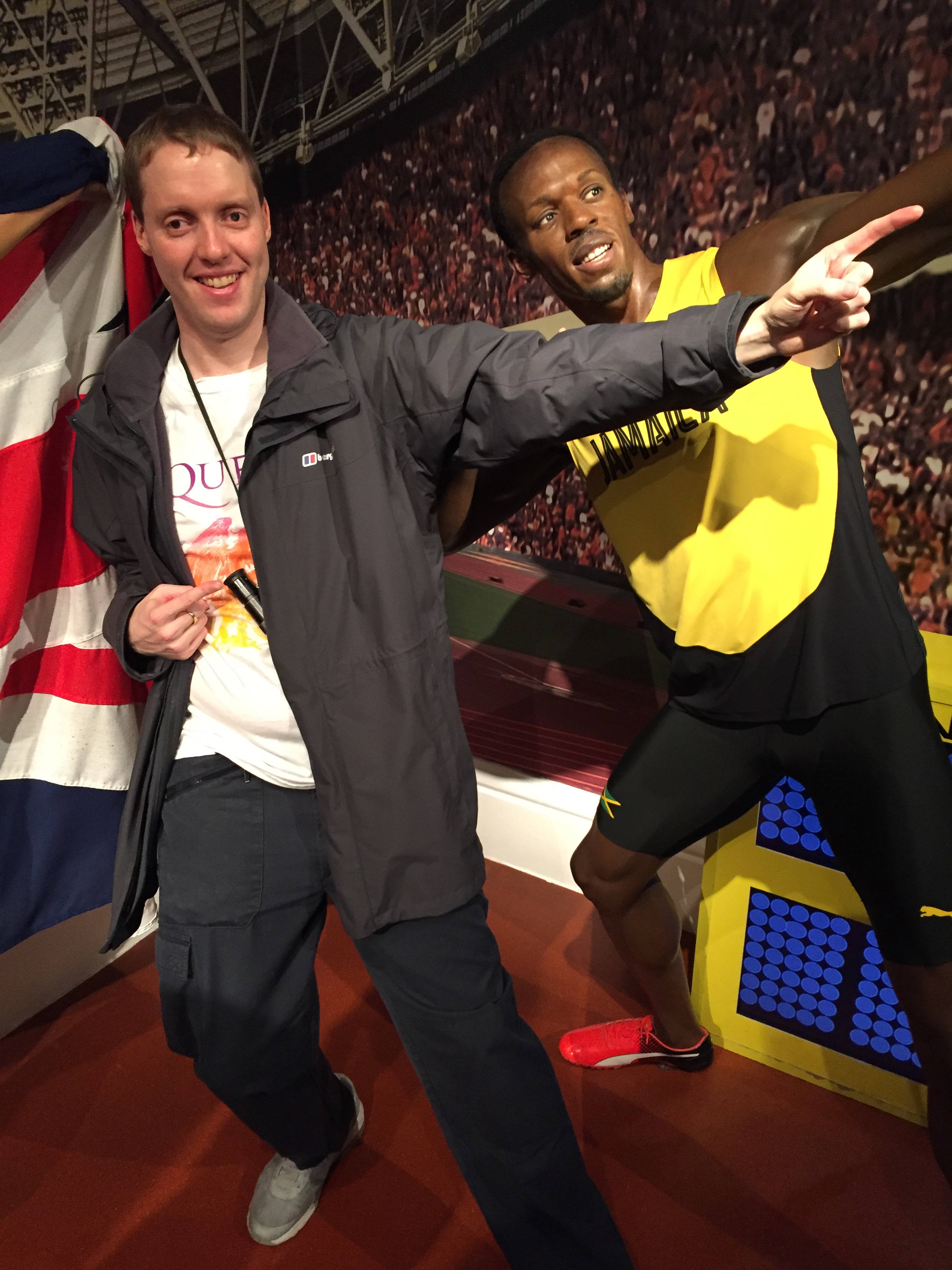 Glen next to Usain Bolt's waxwork at Madame Tussaud's, copying his lightning bolt pose where he leans on his back foot while pointing up and ahead with the opposite arm.