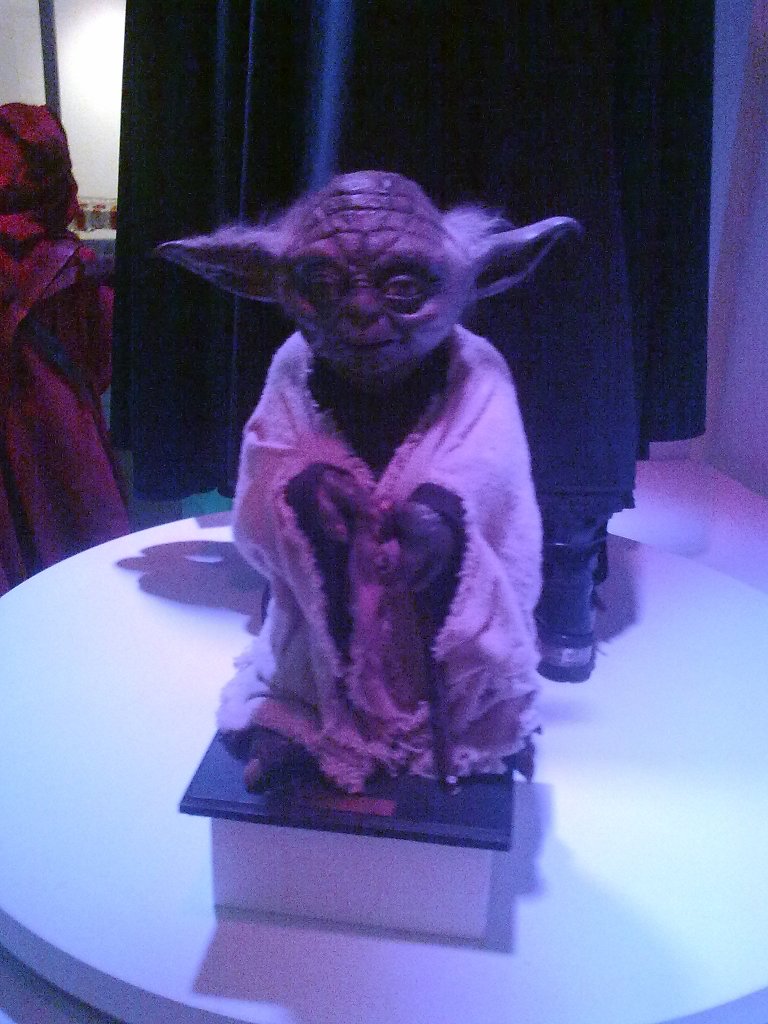 Life-size model of Yoda, the small alien creature with sticking out pointy ears from Star Wars.