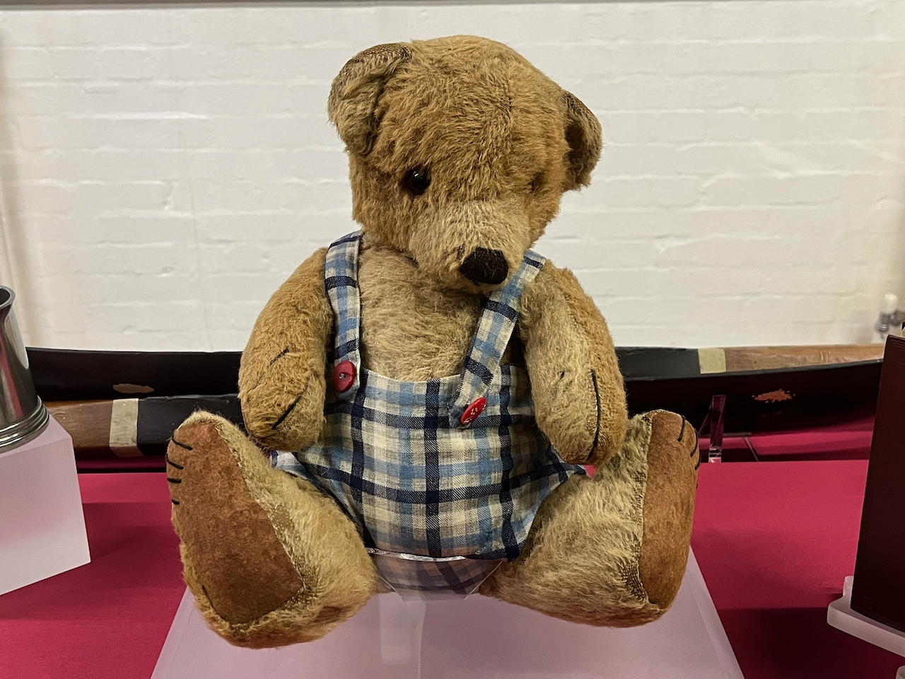 Alan Turing's teddy, a brown bear wearing a sleeveless top with a light coloured tartan style design.