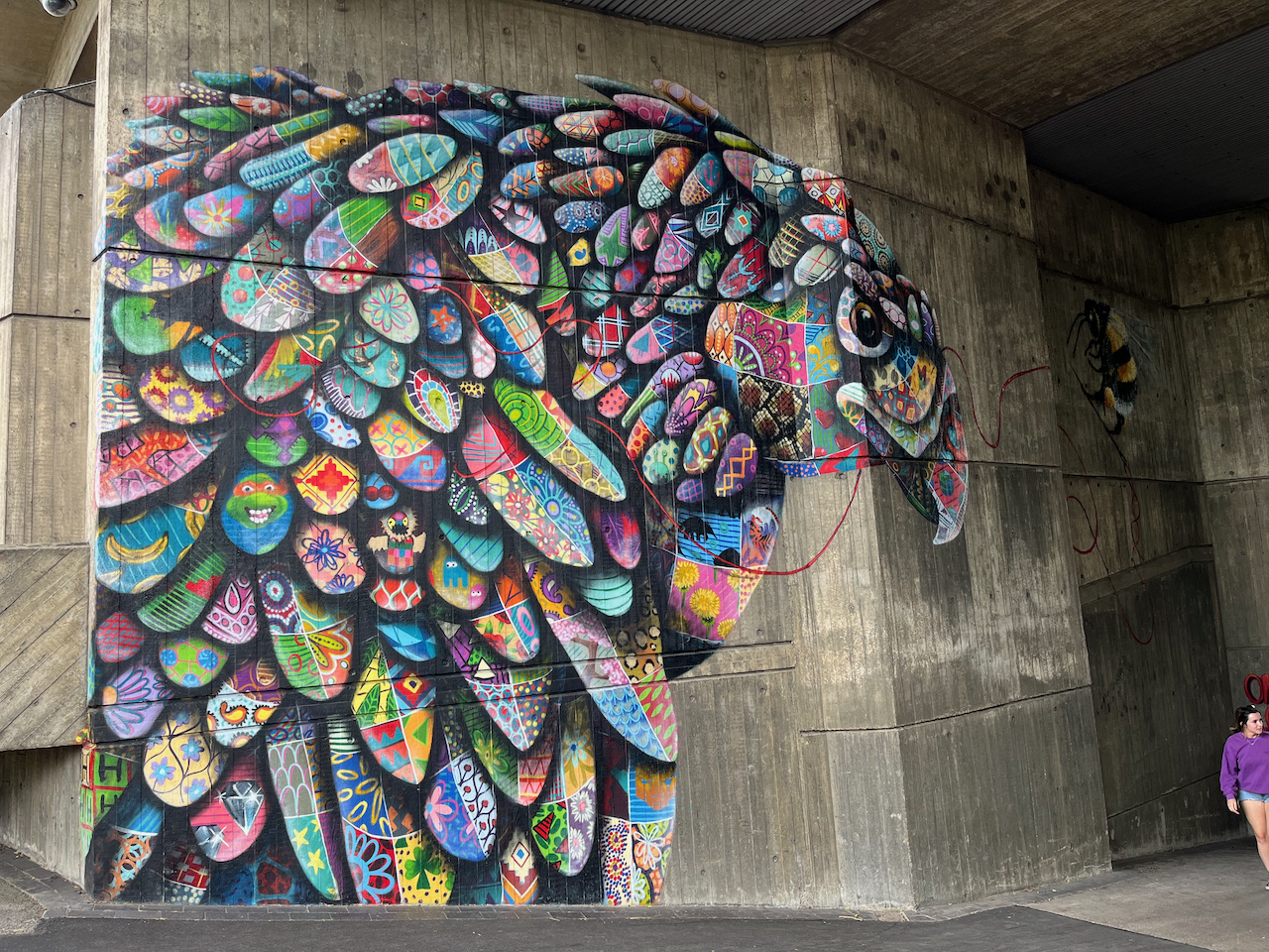 A large wall mural of a Philippine Eagle, made up of lots of different colourful patterned egg-shaped patches, one of which contains the face of a Teenage Mutant Ninja Turtle.