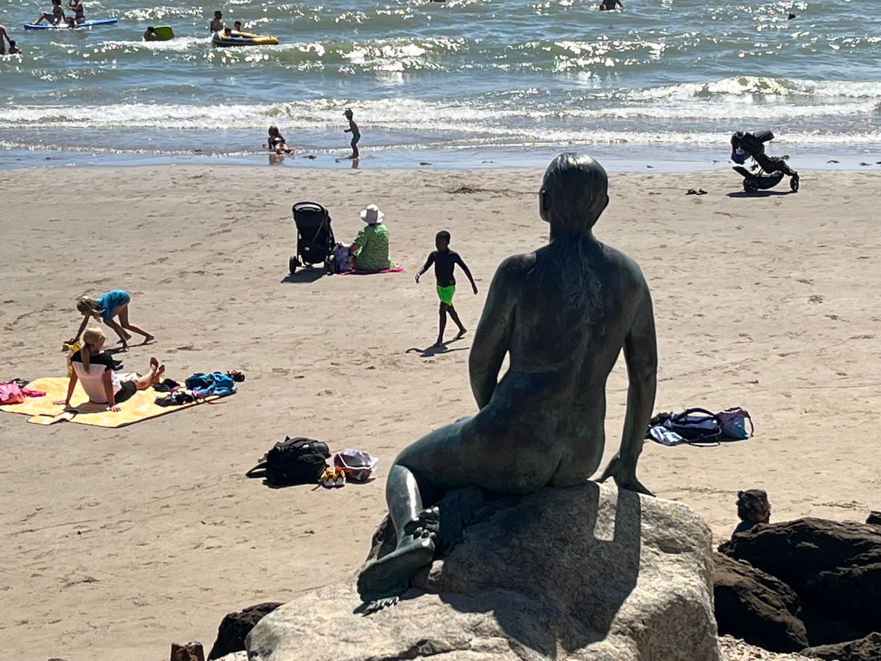 A statue of a mermaid sitting on a rock, overlooking Sunny Sands beach in Folkestone.