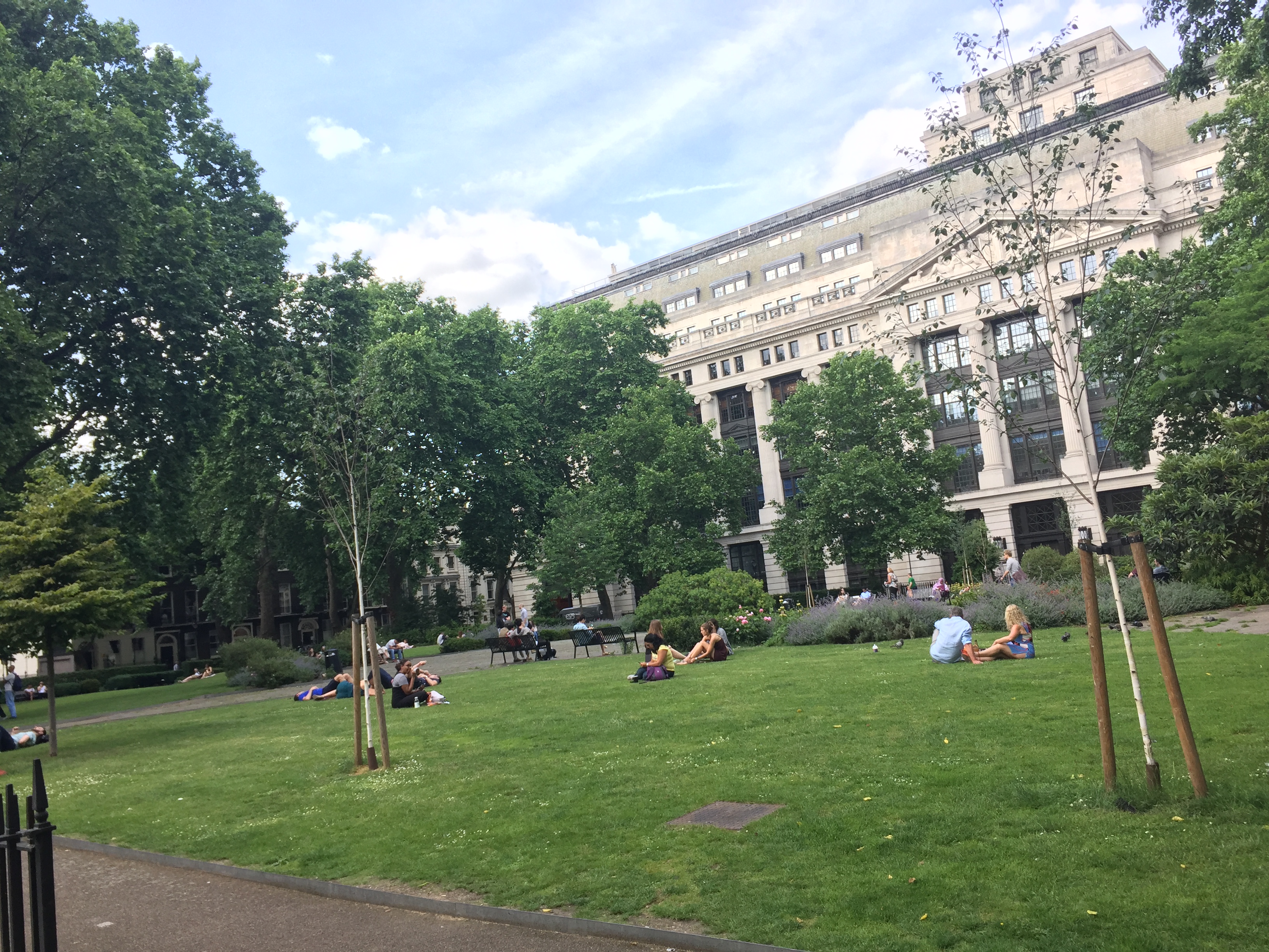 People relaxing on the grass in Bloomsbury Square.
