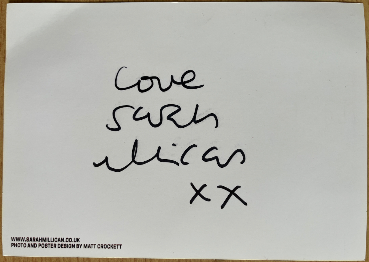 Handwritten text on the back of a postcard that says Love Sarah Millican X X.